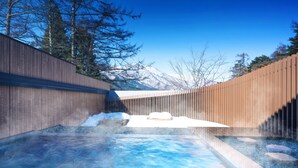 A spa area with a hot tub, wooden walls, and a view of snow-capped mountains. - Hoshino Resorts KAI Alps (Omachi)