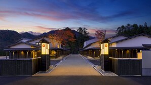 A row of traditional-style buildings with a central pathway leading to a mountain backdrop. - Hoshino Resorts KAI Alps (Omachi)
