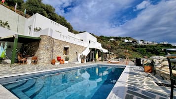 Una piscina al aire libre, tumbonas