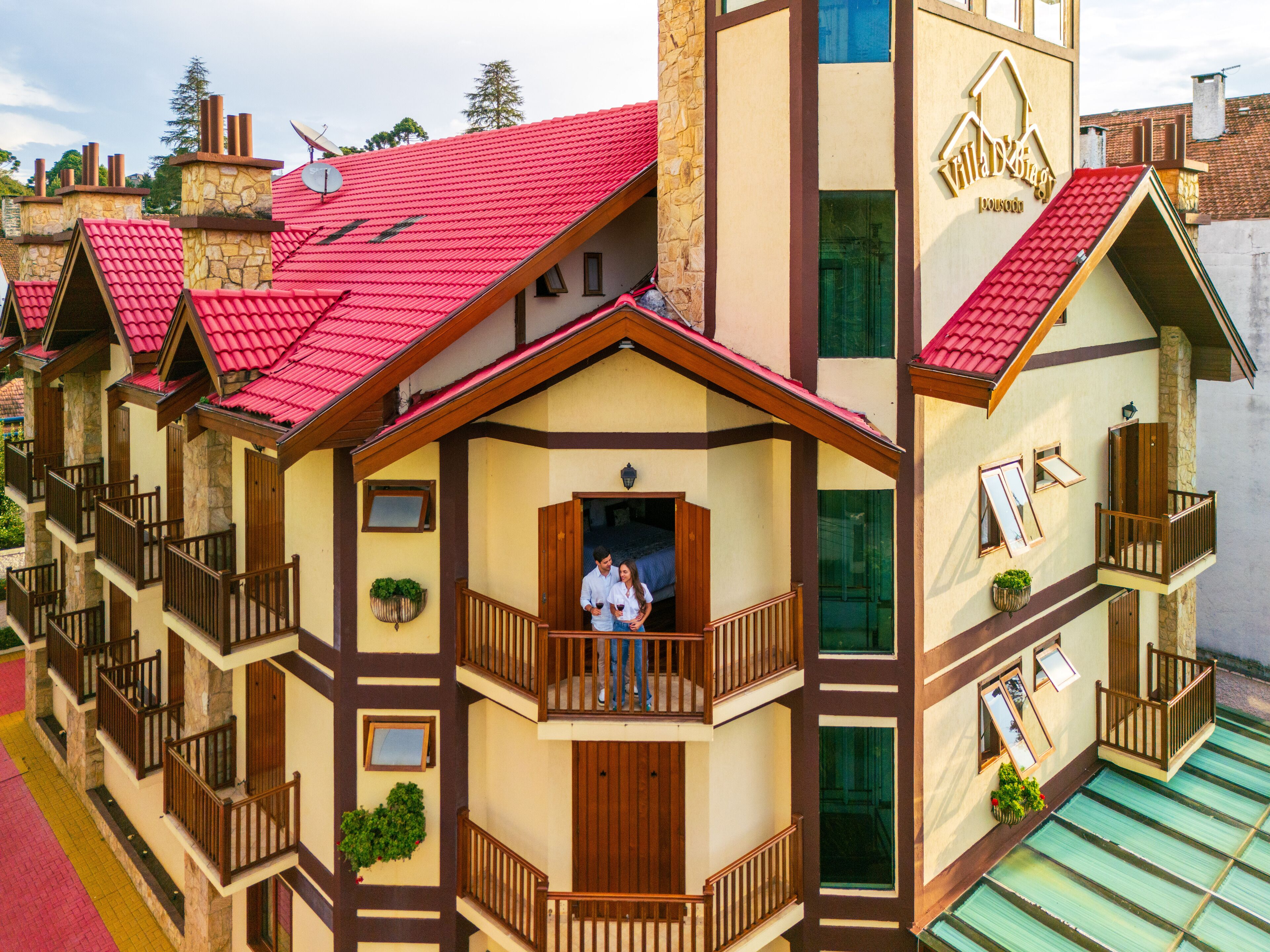 Un immeuble à plusieurs étages, doté de balcons et surmonté d’un toit recouvert de tuiles rouges.