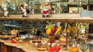 Un buffet proposant une variété de plats et une statuette de chef.
