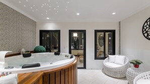 Une salle de bain moderne avec une baignoire sur pieds, un banc en bois et un sol carrelé de blanc.