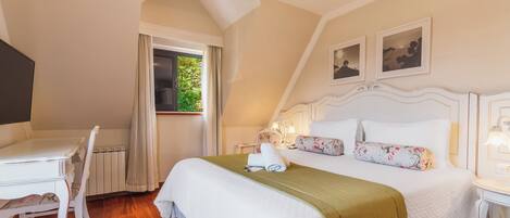 A bedroom with a bed, a desk, and a chair. There is a window with curtains, a radiator, and a picture on the wall.