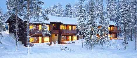 Vista frontal de la propiedad por la tarde o noche