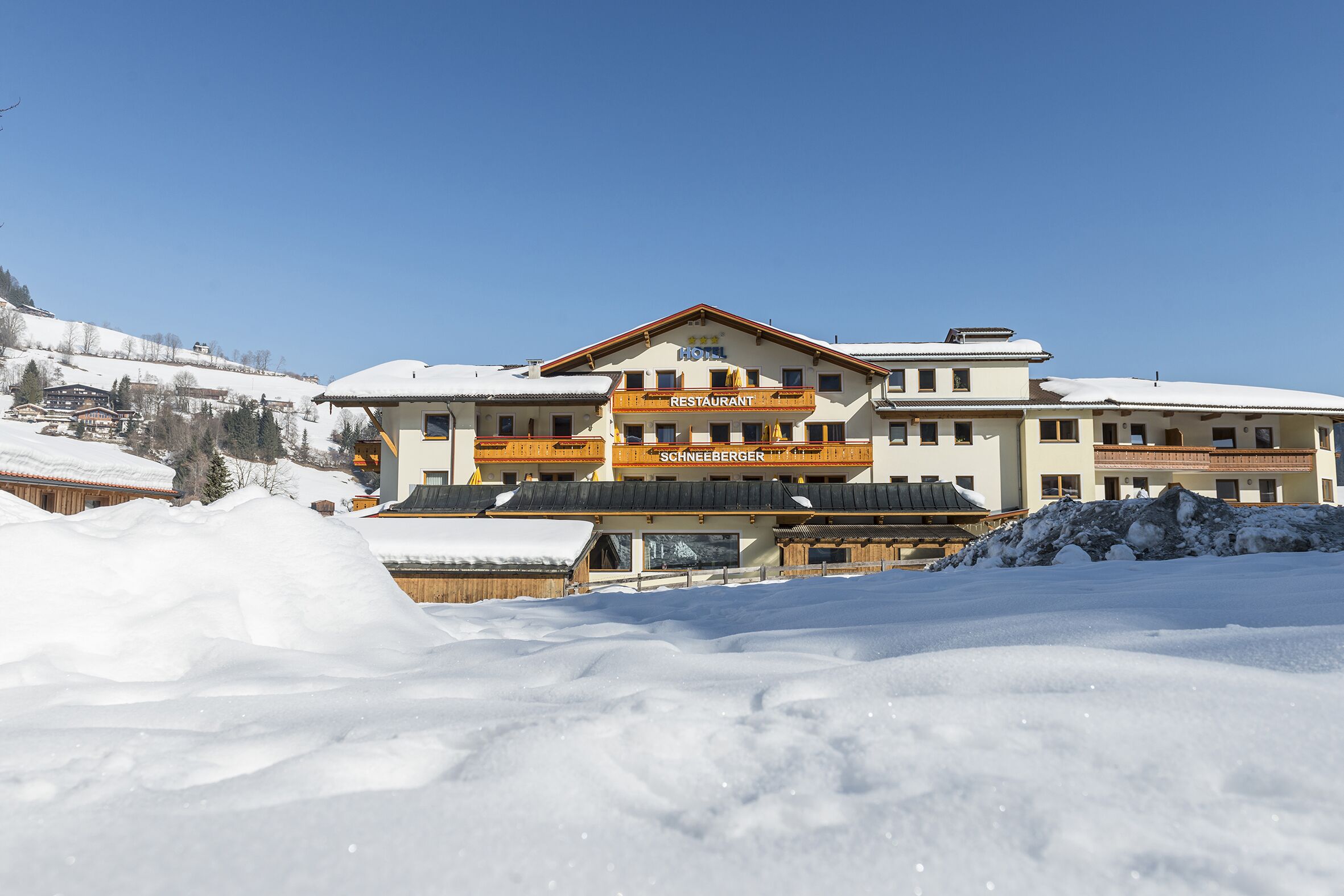 A hotel with a restaurant on the second floor, surrounded by snow.