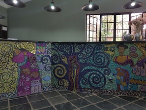 A mosaic wall with geometric patterns and a tiled floor. - Izimbali Lodge (Ermelo)