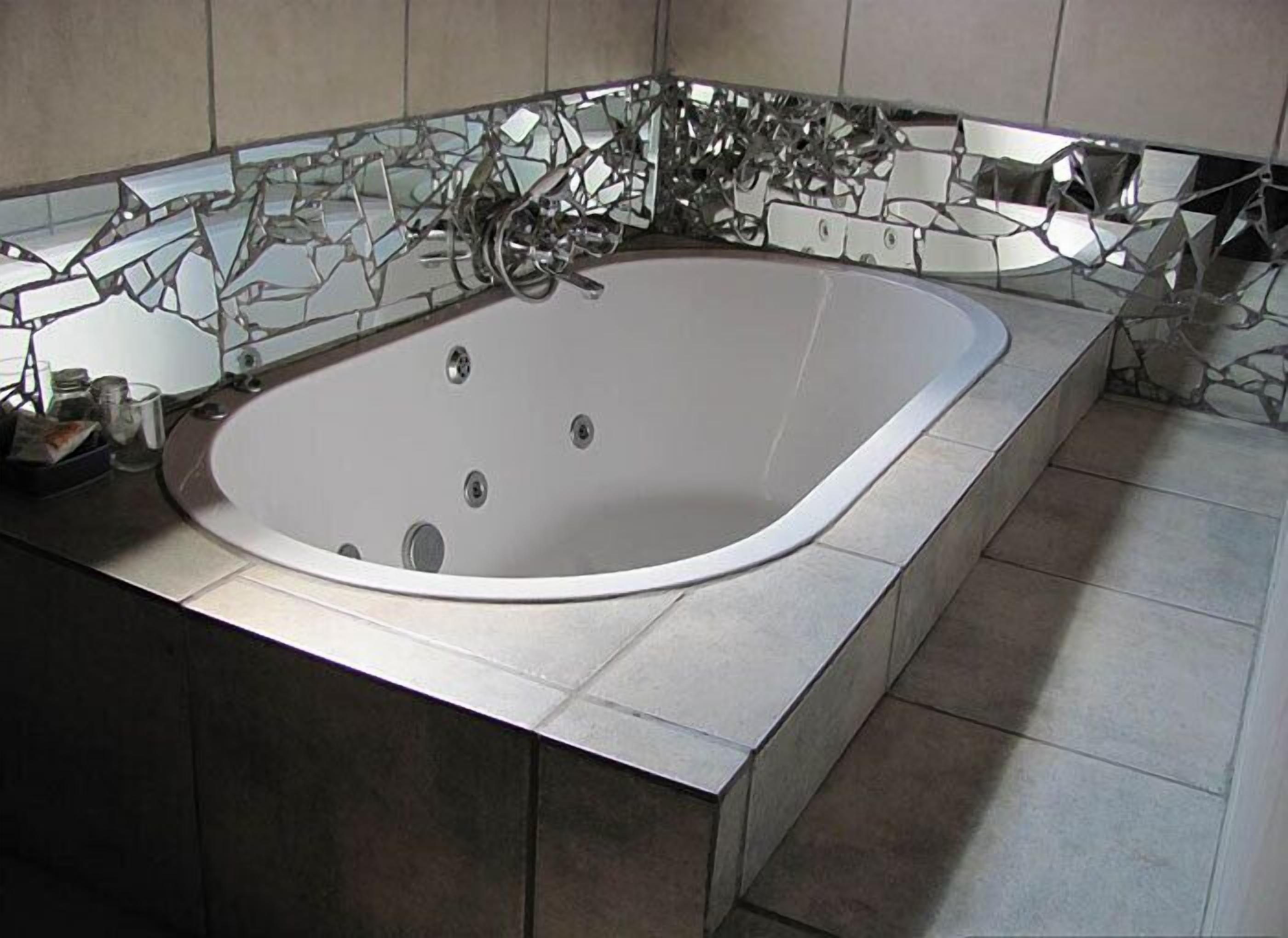 Un baño moderno con una bañera independiente, paredes y piso cubiertos de azulejos.