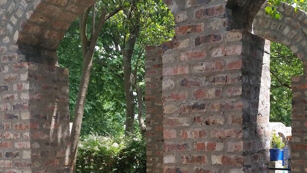 A brick archway with a garden path leading through it. - Izimbali Lodge (Ermelo)