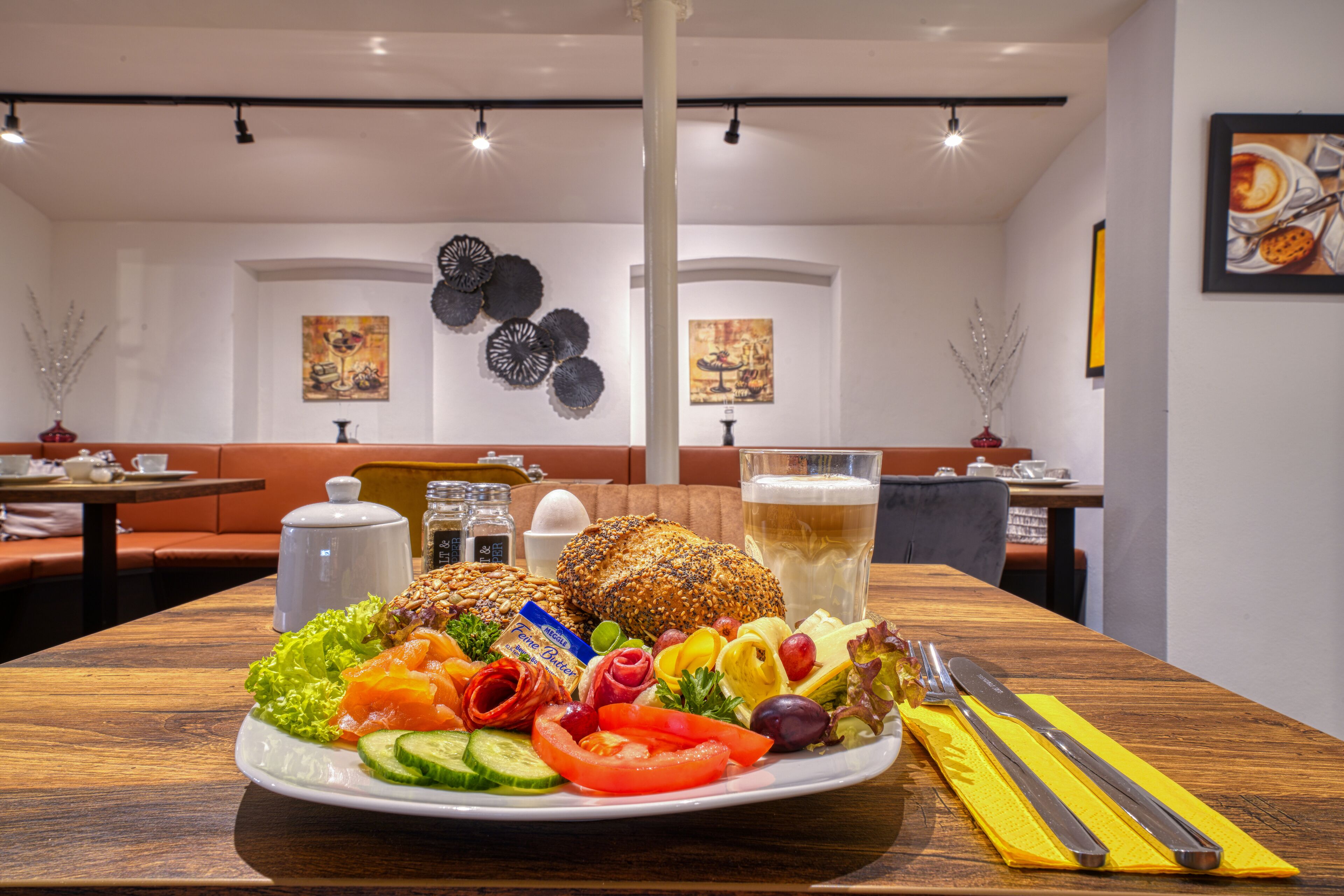 Une table à manger où l’on trouve une variété d’aliments, notamment des légumes, du pain et un verre de bière.