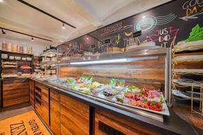 Un esmorzar buffet amb diverses opcions gastronòmiques, una pissarra amb frases motivacionals i una decoració interior de fusta.