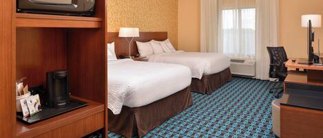 A hotel room with two beds, a minibar, a desk with a computer, and a large window with curtains.