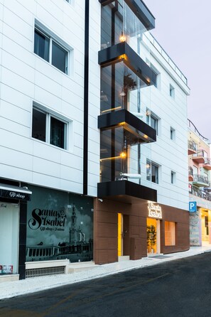 Un edificio moderno con una tienda de regalos en la planta baja y un restaurante llamado 'Santa Isabel' en el segundo piso.