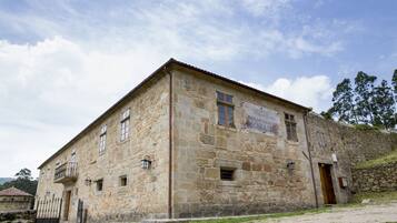 A stone building with a sign indicating it is a hotel.