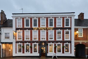 A traditional pub named "The White Hart" with a classic facade, multiple windows, and a welcoming entrance.