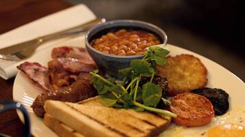 A plate of food with beans, bacon, eggs, and toast.