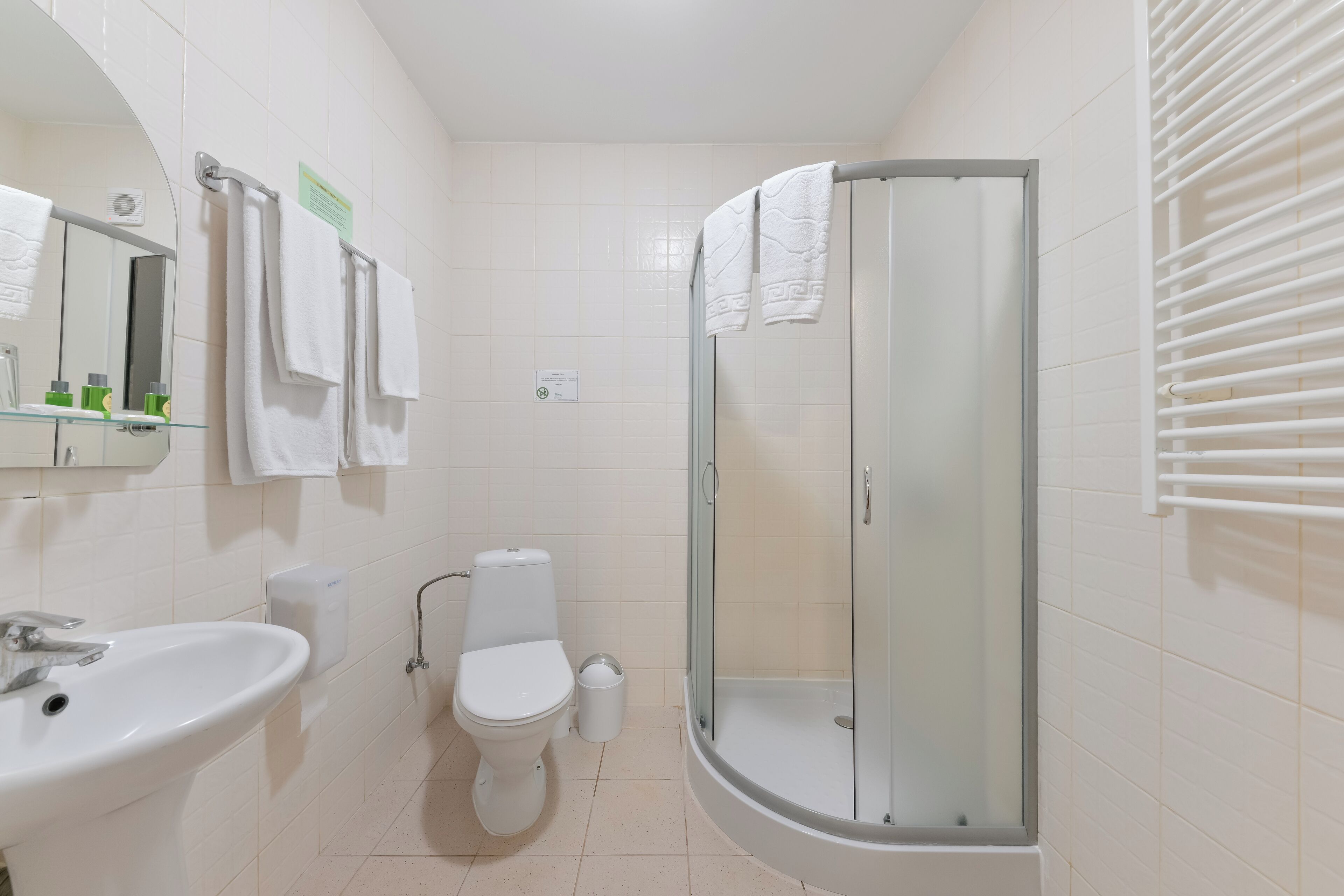A modern bathroom with a glass-enclosed shower, a white sink, and a toilet.