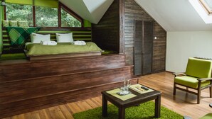 Une chambre avec un lit en mezzanine, une chaise verte et une table en bois.