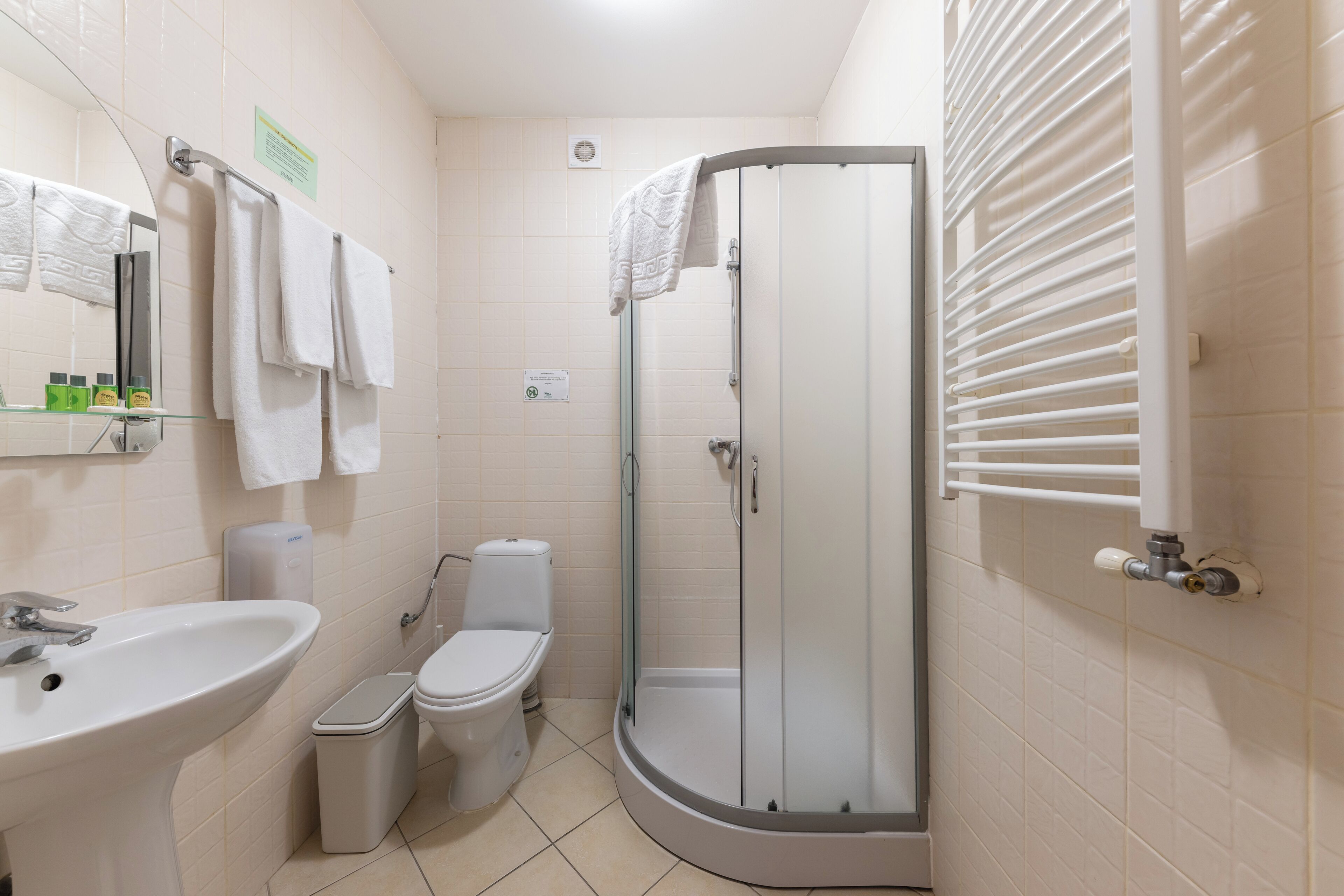 A bathroom with a sink, toilet, and glass-enclosed shower.
