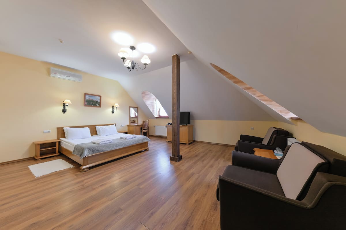 Un dormitorio con cama, escritorio, silla y televisor.