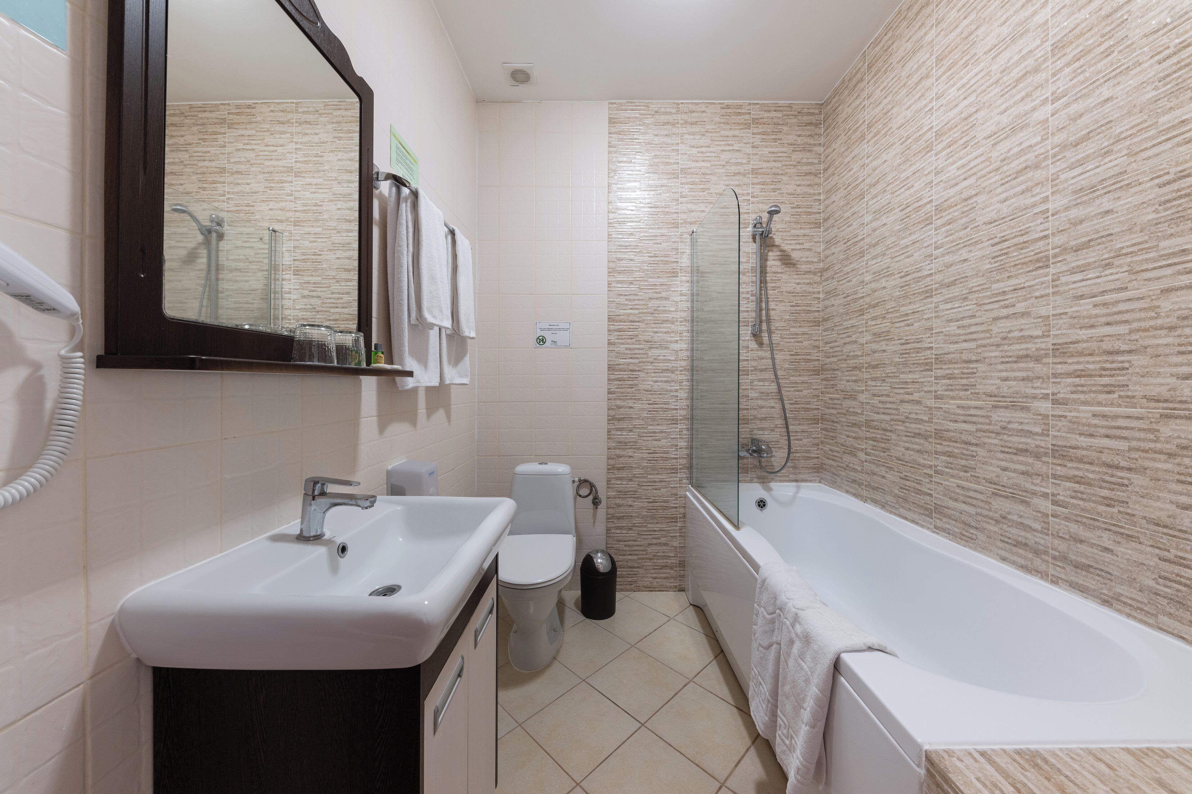 A modern bathroom with a sink, toilet, and bathtub.