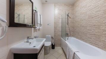 A modern bathroom with a sink, toilet, and bathtub.