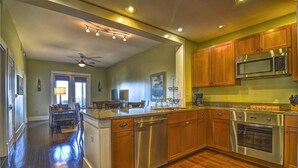 Une cuisine moderne avec des meubles en bois, des appareils en acier inoxydable et un îlot central.