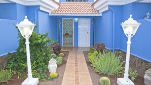 A pathway leading to a blue building with a tiled roof, white door, and numbered doors. - Be Cool Resort - Adults Only (San Bartolomé de Tirajana)