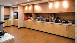 A modern kitchen with wooden cabinets, stainless steel appliances, and a clean, organized layout. - TownePlace Suites by Marriott Austin Round Rock (Austin)