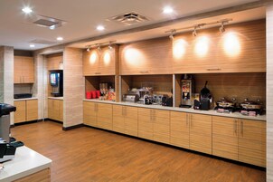 Una cocina moderna con armarios de madera, electrodomésticos de acero inoxidable y una distribución limpia y ordenada.