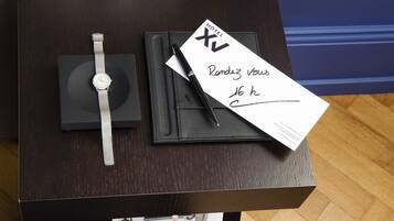 A watch, a pen, and a hotel receipt on a table.