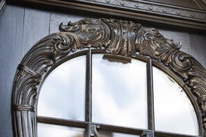 An ornate, dark wooden door with intricate carvings and a glass panel. - Boutique Hôtel des XV (Strasbourg)