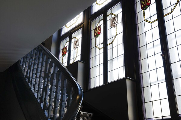 A spiral staircase with a view of stained glass windows. - Boutique Hôtel des XV (Strasbourg)