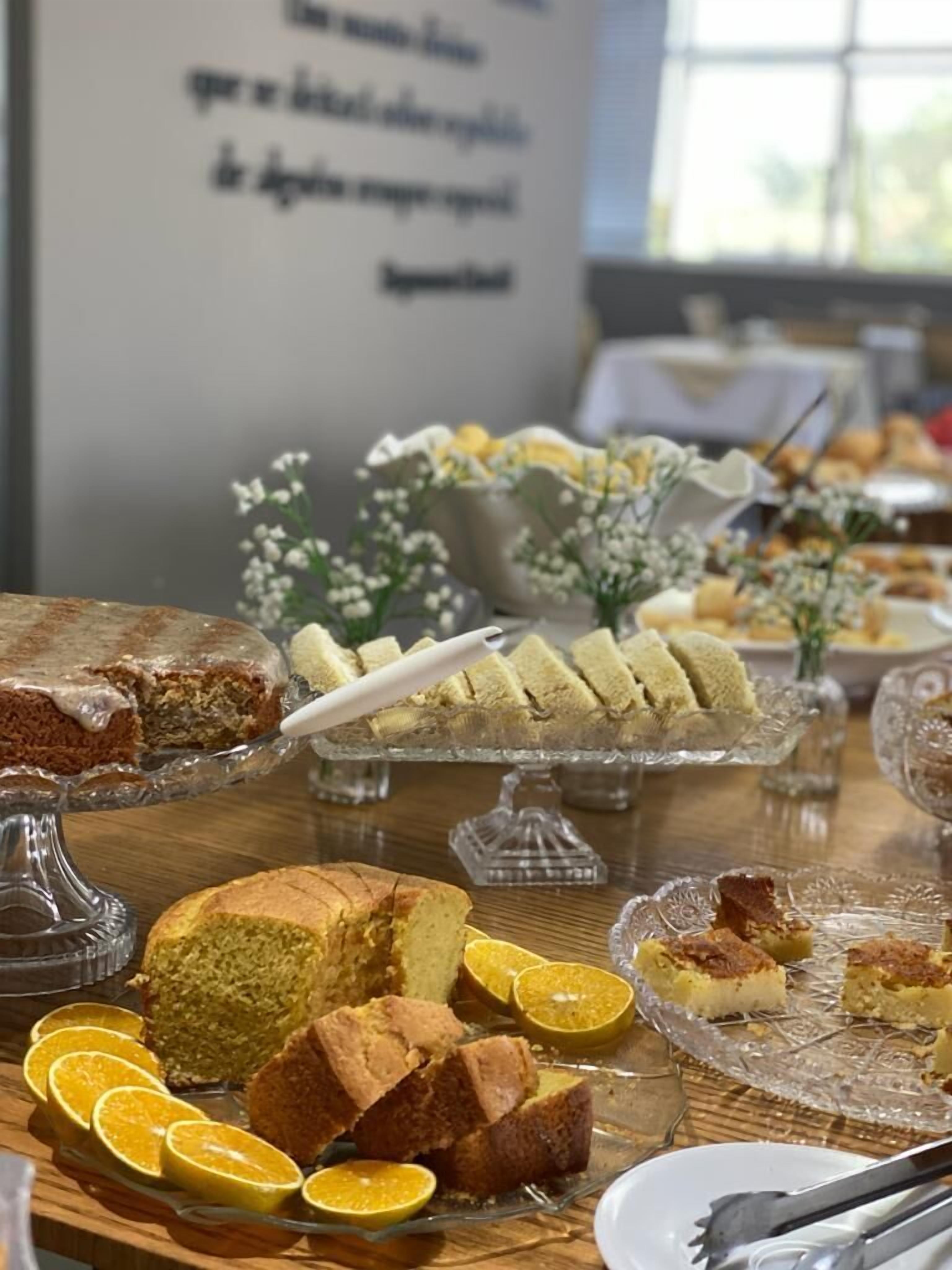 A buffet table with various food items, including cakes and pastries, arranged on glass stands.
