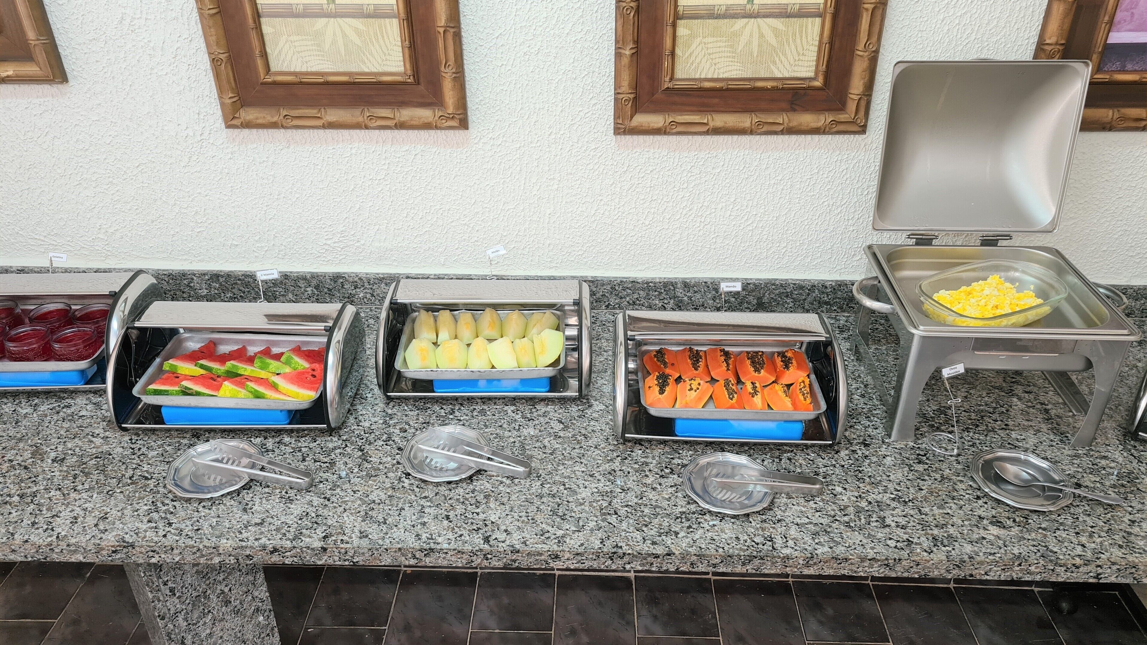 A buffet with various food items including watermelon, melon, and papaya.