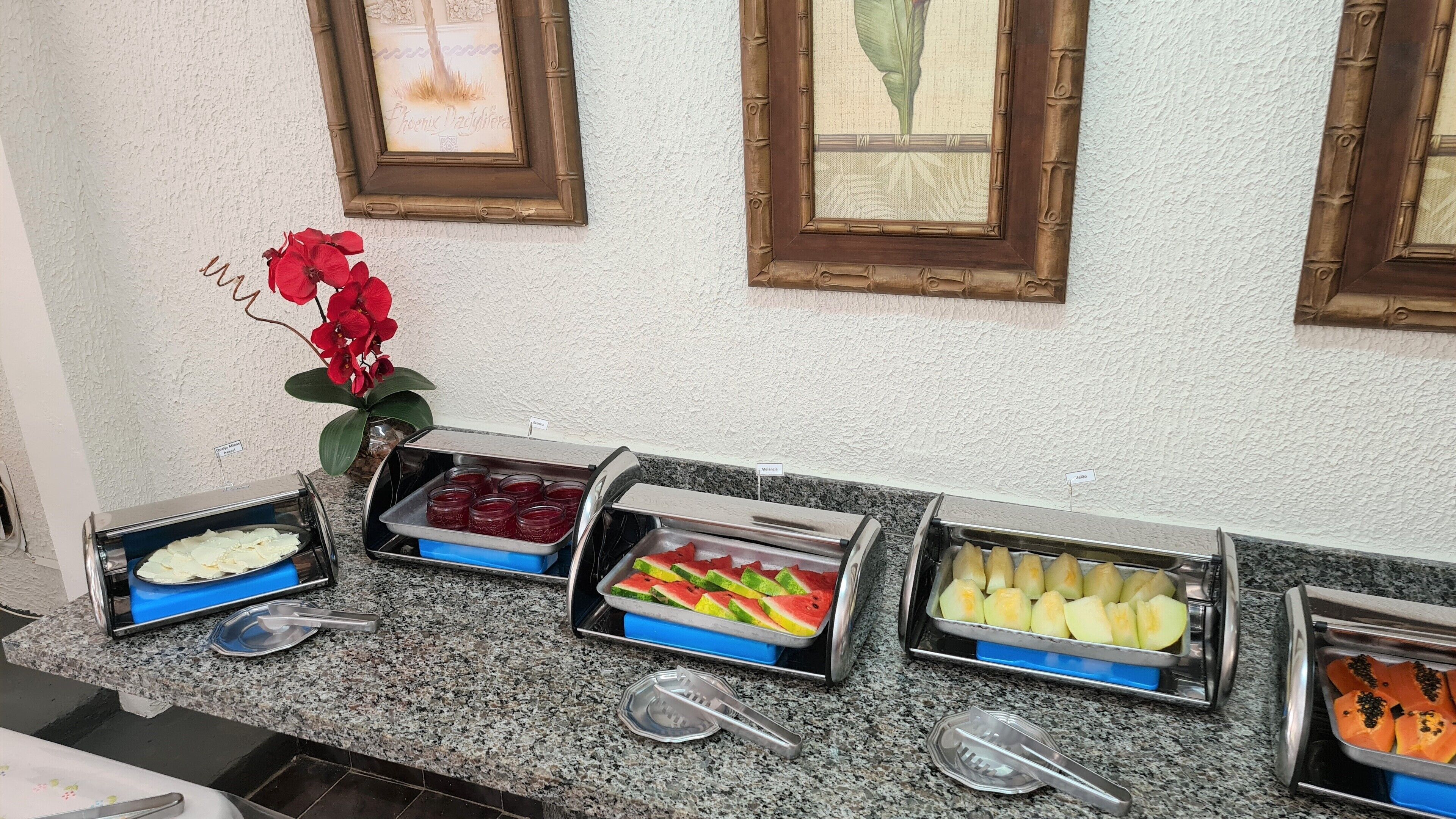 Un buffet proposant une variété de plats, notamment des fruits, des légumes et des desserts.
