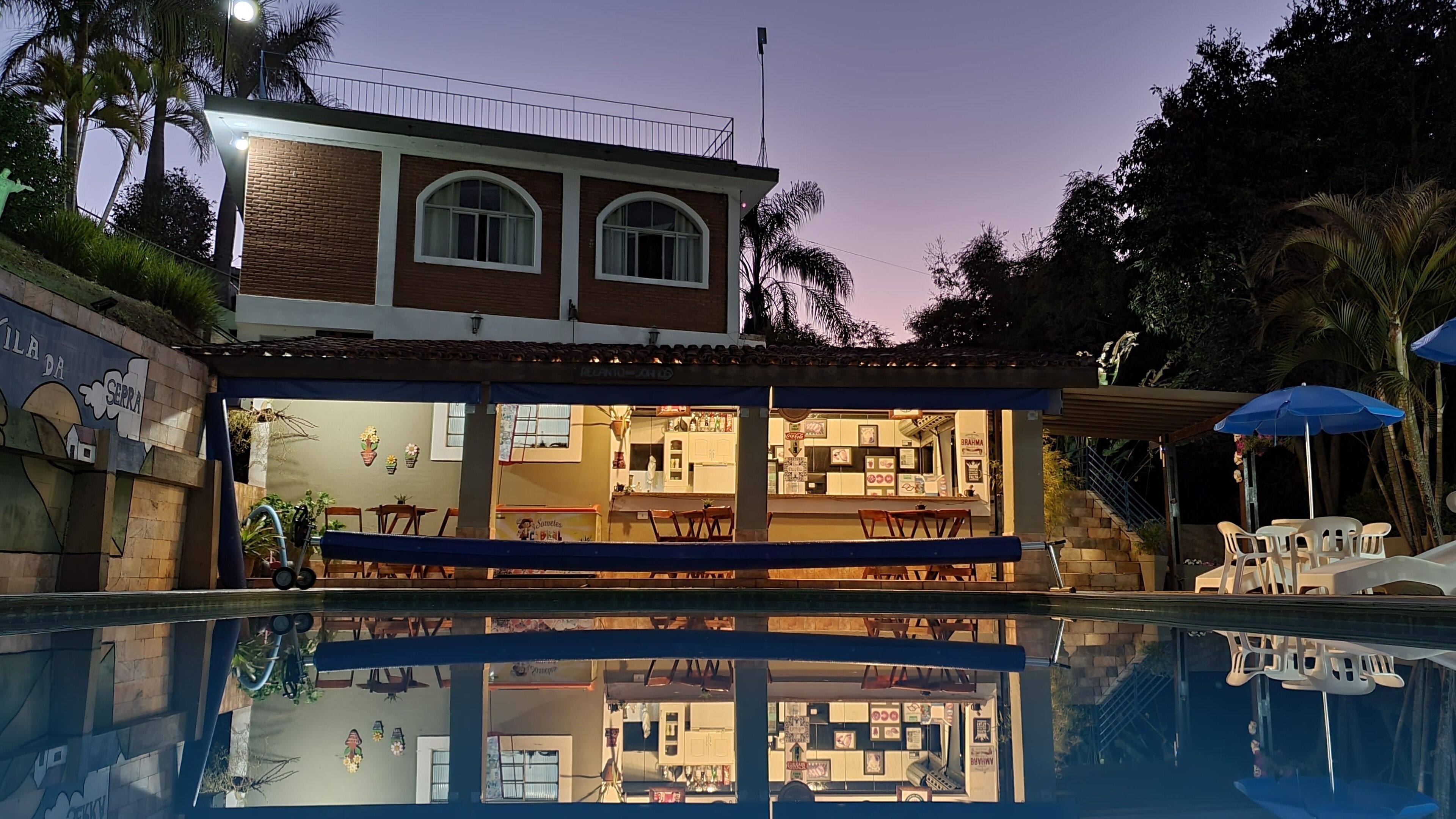 A two-story building with a swimming pool in front.