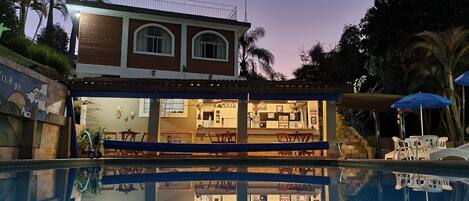 A two-story building with a swimming pool in front.