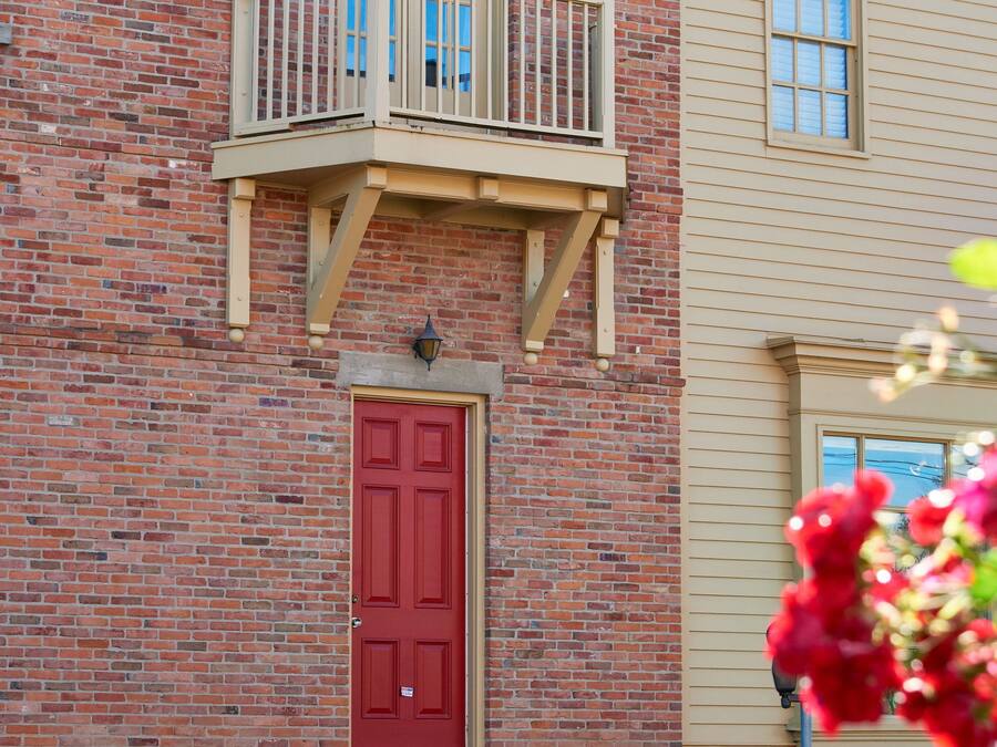A two-story building with a red door and a balcony.