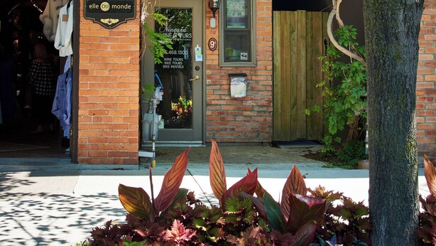 Un bâtiment en briques avec une devanture de magasin et une porte en bois.