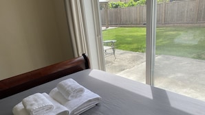 Una camera d'albergo con un letto, una finestra e vista su un giardino.