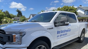 Un pick-up bianco con un'insegna laterale pubblicitaria per un bed and breakfast.
