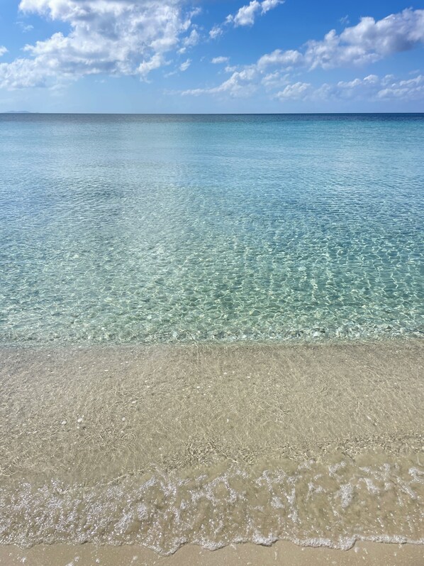 On the beach, white sand, sun-loungers, beach towels