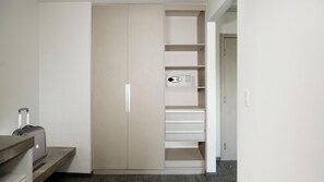A walk-in closet with a built-in microwave, multiple drawers, and a suitcase on a bench. - Life Hotel (Oaxaca)