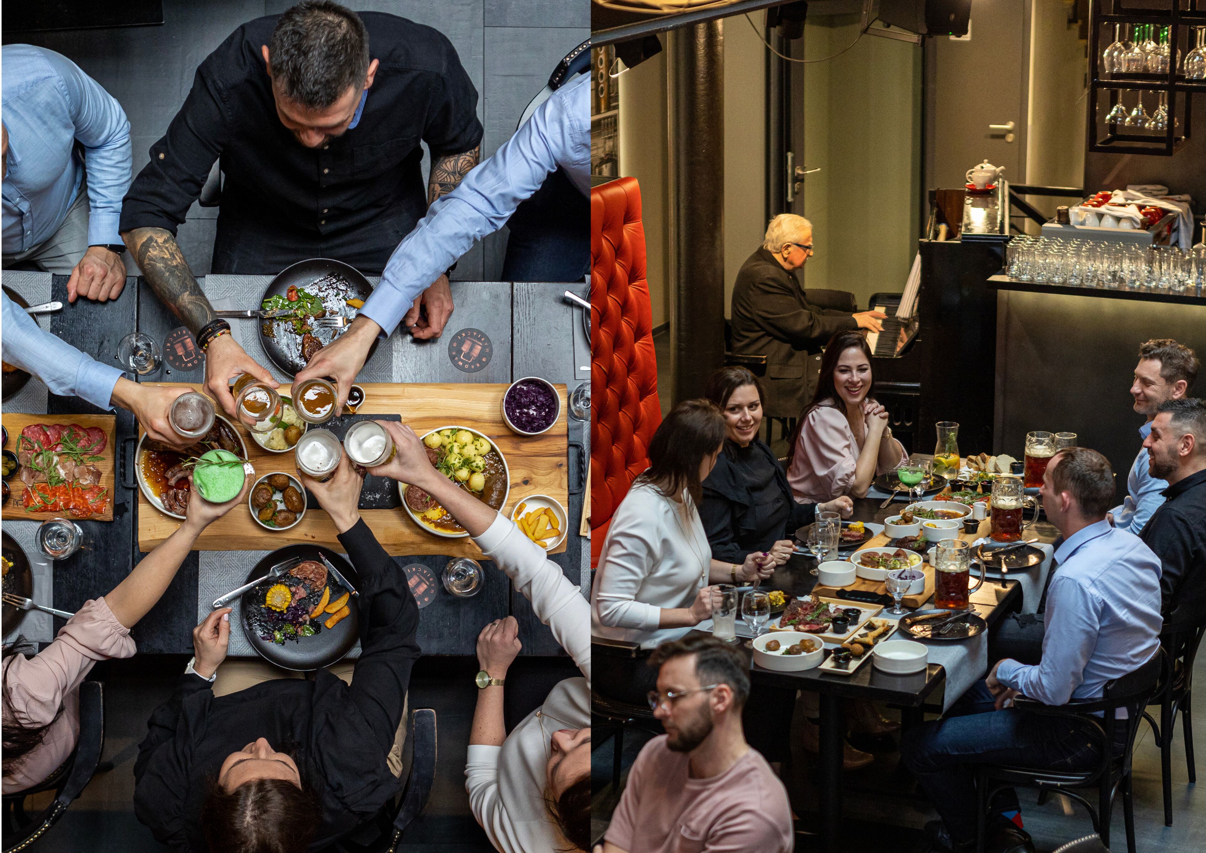 Un comedor con varias mesas, algunas con personas sentadas y otras de pie. Hay diferentes platos y bebidas sobre las mesas.