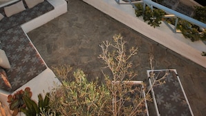 A rooftop pool area with a view of the sunset and a church in the background.