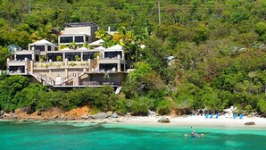 A beachfront property with multiple buildings, a sandy beach, and clear turquoise waters. - The BEST Wedding Spot! 2 pools, gym, beachfront & MUCH MORE! (St. Thomas)