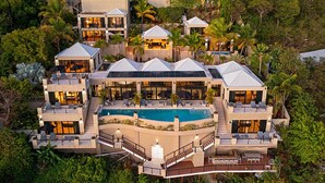 A multi-story resort with a central pool, outdoor seating areas, and lush surrounding vegetation. - The BEST Wedding Spot! 2 pools, gym, beachfront & MUCH MORE! (St. Thomas)