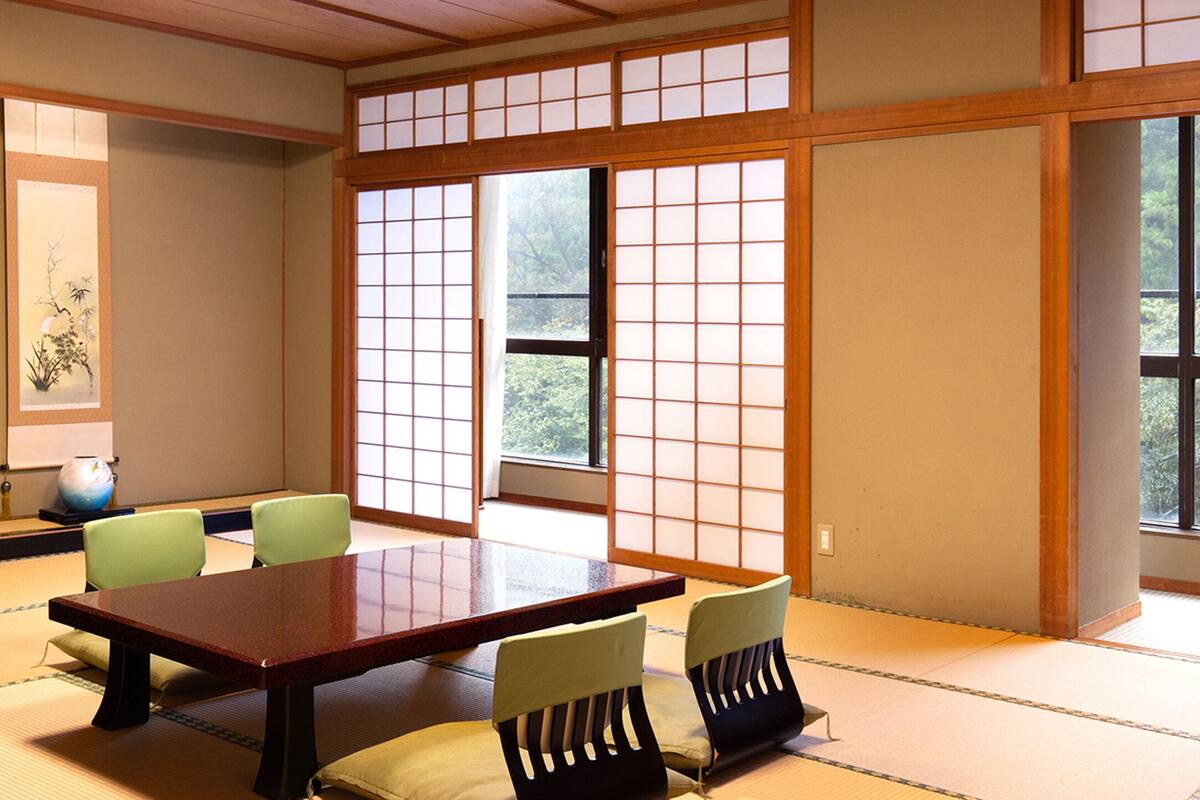 Una habitació tradicional japonesa amb fons de tatami, una taula baixa i panells shoji.