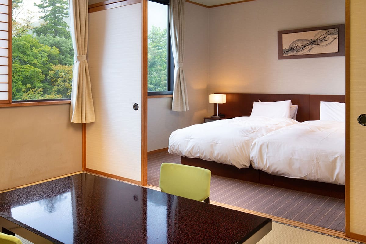 Habitació d'hotel amb un llit, una taula de nit i una cadira.