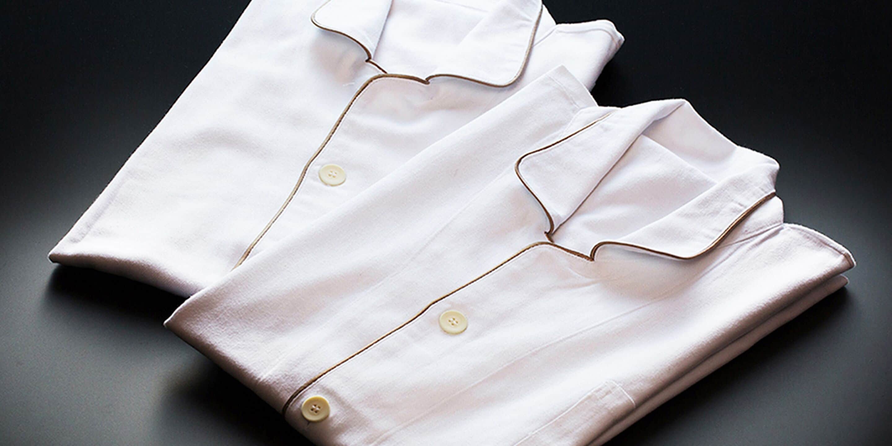 A neatly folded white shirt with a collar and buttons.